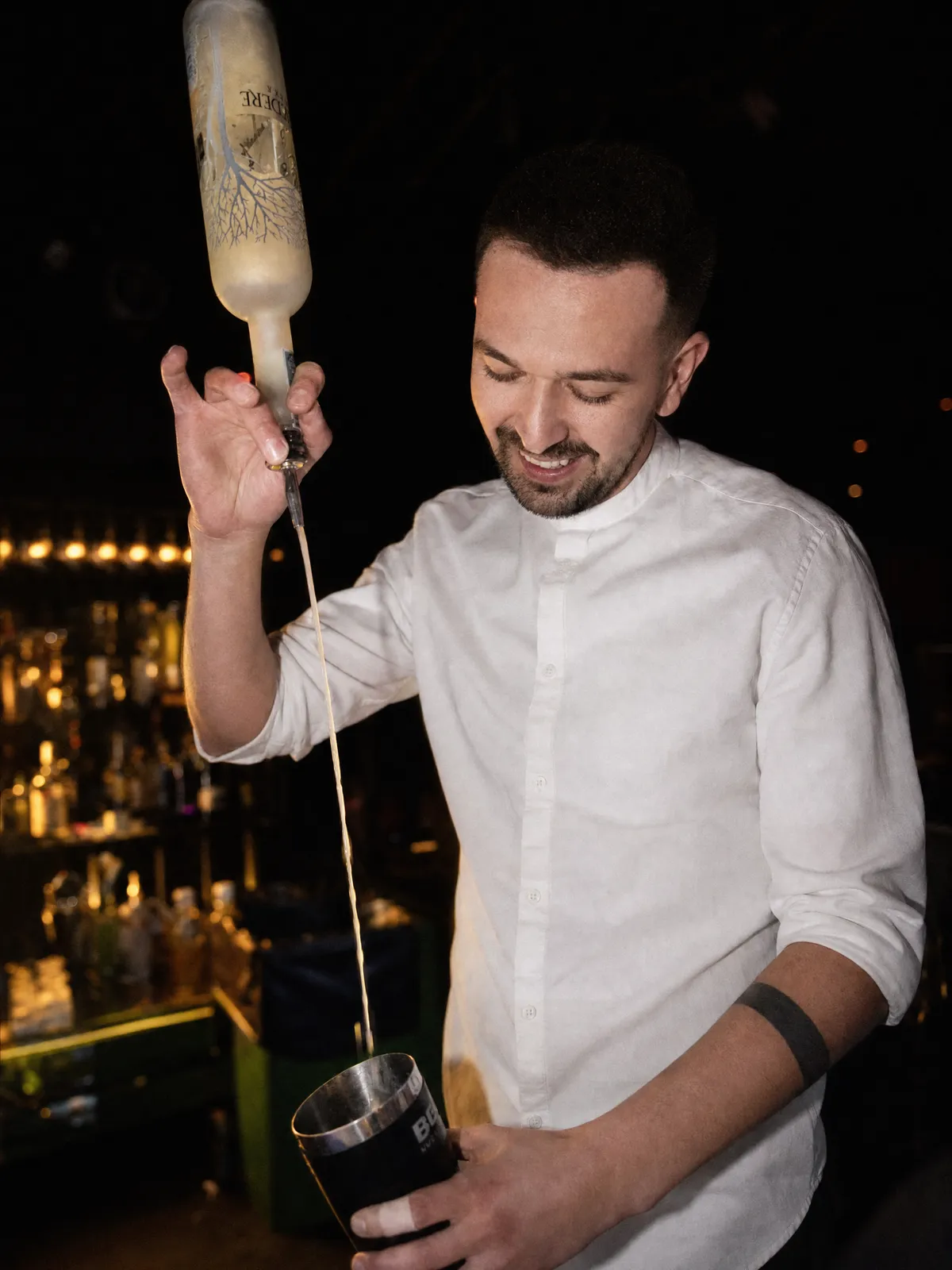 Barkeeper gießt Vodka in einen Shaker